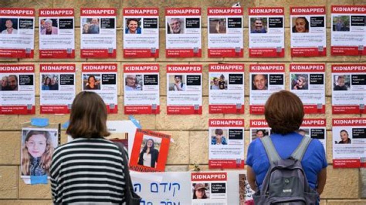 Anti-Israel activist Aya Baraket removes posters showing Israeli children taken by Hamas militants. - SarkariResult